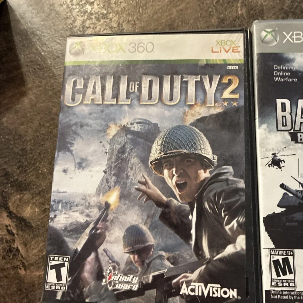 Three Xbox 360 Games, Assassin Creed, Battlefield, And Call Of Duty